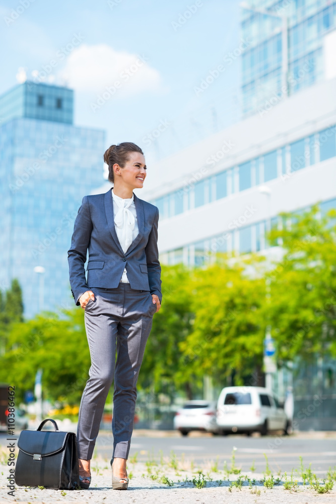 Business woman with briefcase standing in modern office district Business woman with briefcase standing in modern office district