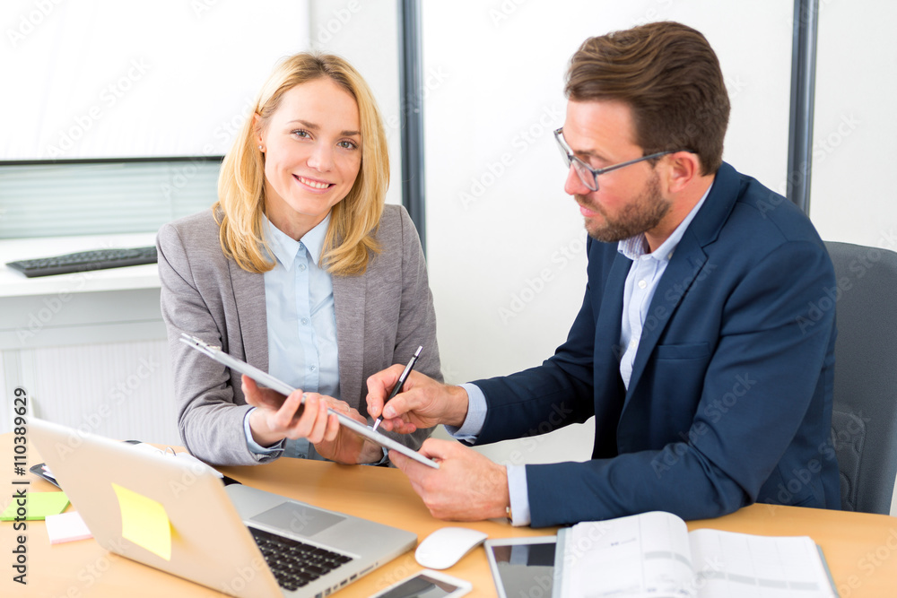 Businessman and his assistant working together at the office Businessman and his assistant working together at the office