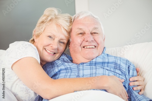 Portrait of happy senior couple lying on bed