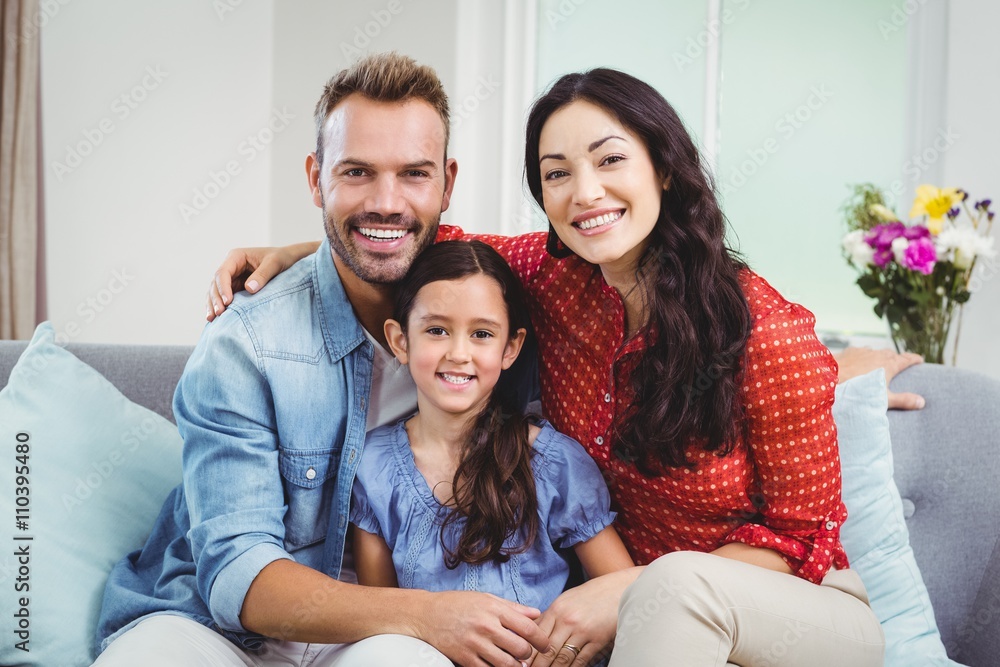 Happy parents sitting with daughter on sofa Happy parents sitting with daughter on sofa