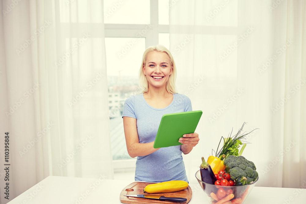 smiling young woman with tablet pc cooking at home smiling young woman with tablet pc cooking at home
