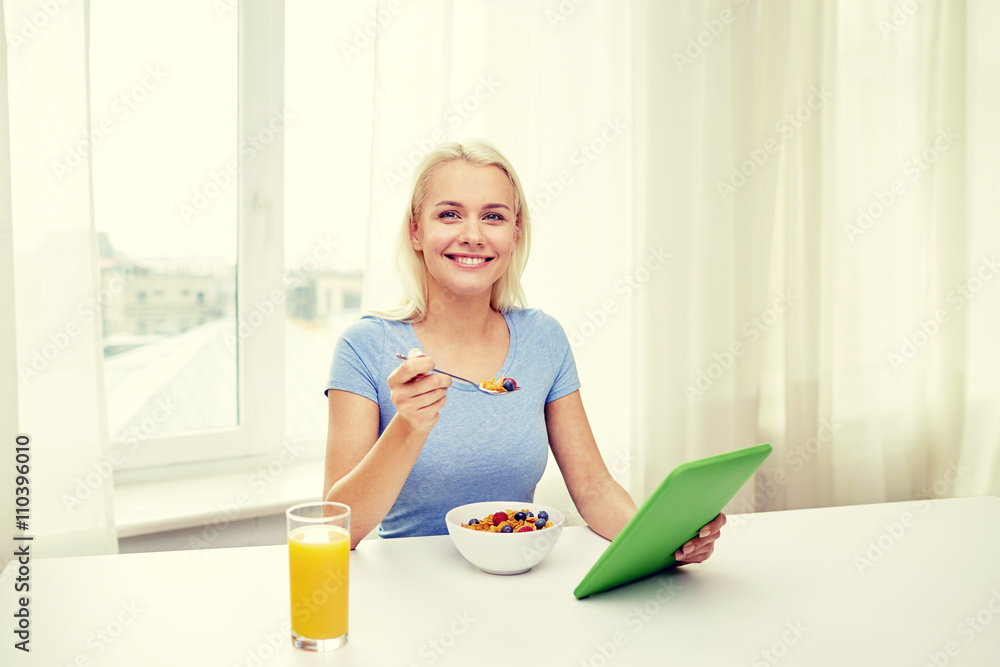 woman with tablet pc eating breakfast at home woman with tablet pc eating breakfast at home