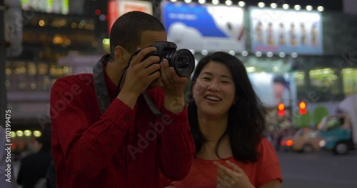 Mixed race man takes photos with his asian girlfriend a shibuya tokyo crossing Japan 4k  photo