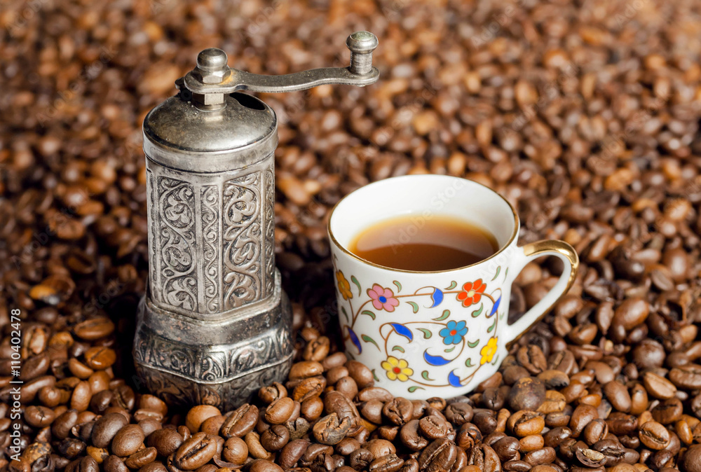 Still life of coffee beans and coffee grinder with oriental style cup of coffee