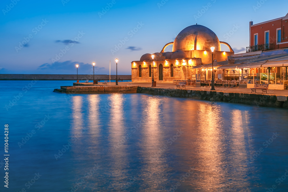Fototapeta premium Picturesque view of Venetian quay of Chania with Kucuk Hasan Pasha Mosque during mornng blue hour before sunrise, Crete, Greece