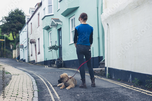 Young woman in street with Leonberger puppy