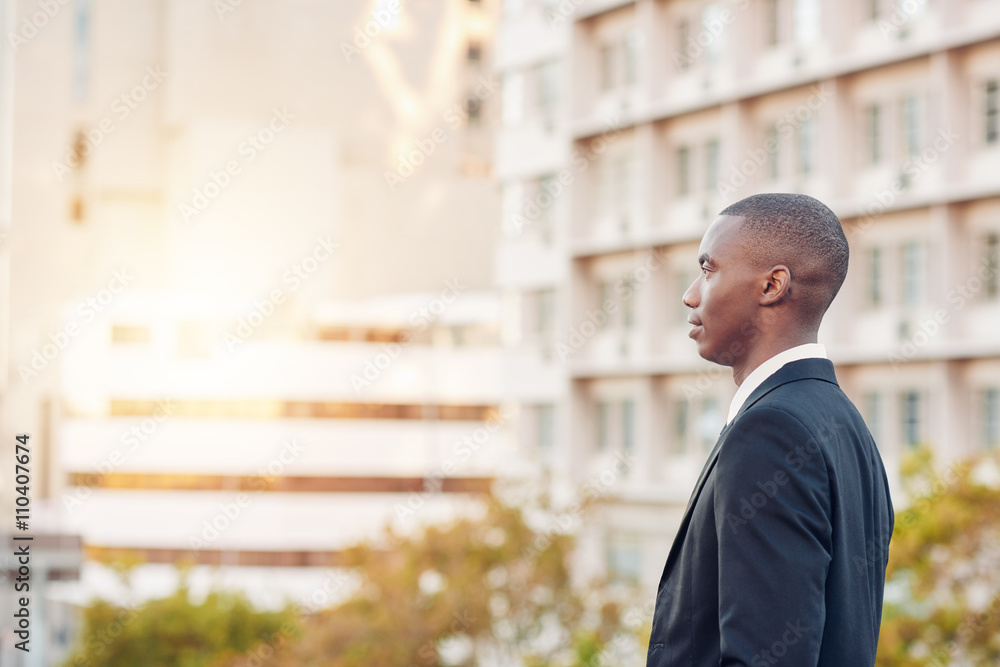 Profile of a young African businesman in city, looking away Profile of a young African businesman in city, looking away