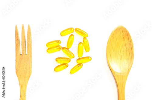 fish oil with wooden spoon and fork isolated white background