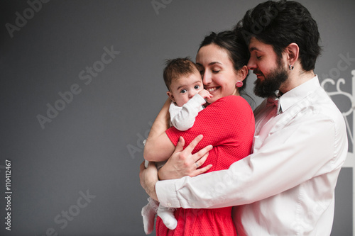 father hugs his wife and daughter