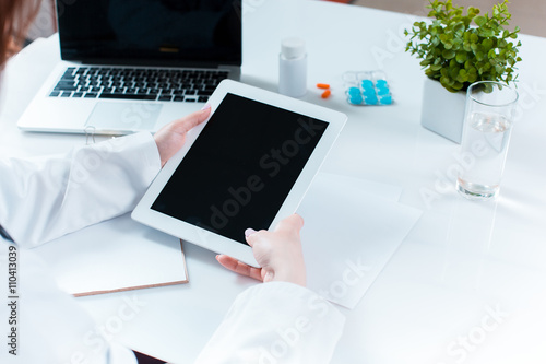 Doctor working on a digital tablet photo