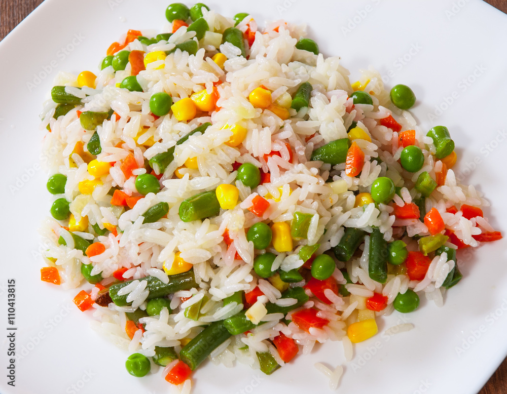 Rice with mixed vegetables on white plate