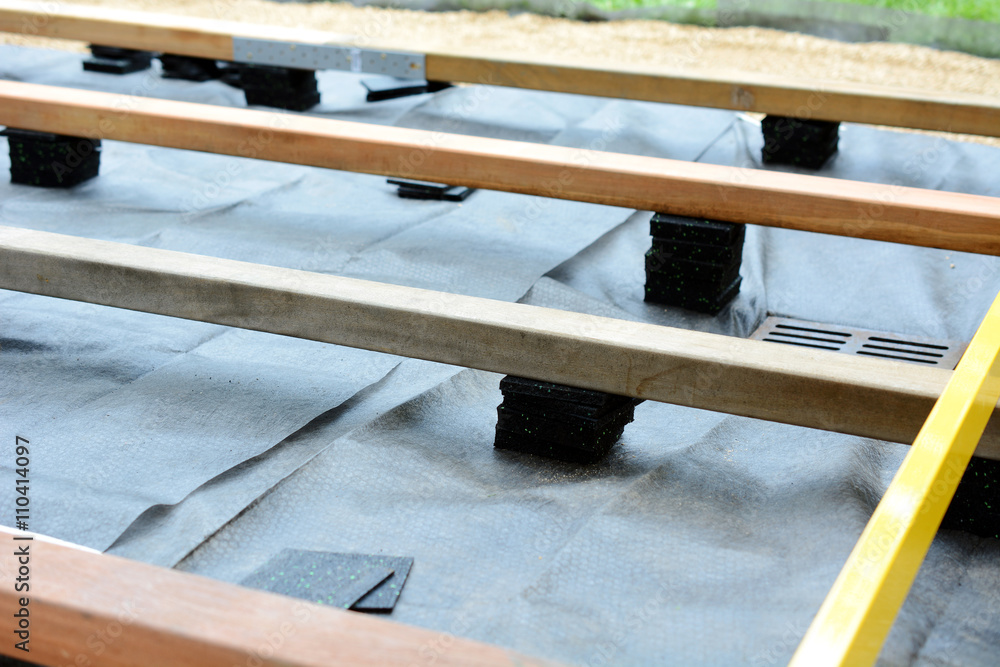 Unterkonstruktion für Terrasse mit Holzbalken und Terrassenpads aus  Granulat und Bautenschutzmatte Photos