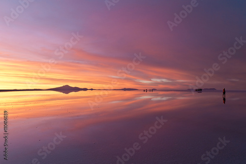 夕日に萌える雲と人のシルエットが反射するウユニ塩湖。Uyuni gradational sunset, clouds and people's silhouette reflected surface of the water.