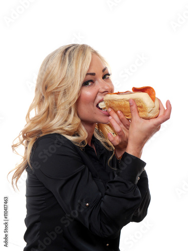 Blond woman eating a sandwich.