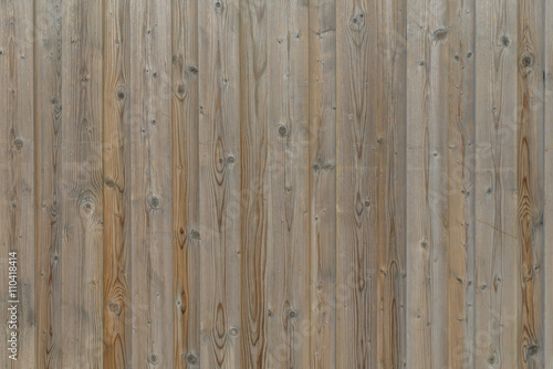 Nahaufnahme einer Holzwand mit verwitterten Holzbrettern der Farbe braun und grau