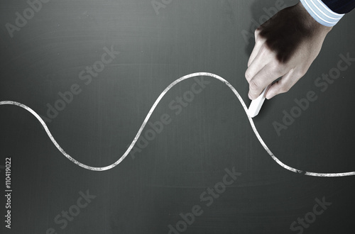Man drawing gears on blackboard