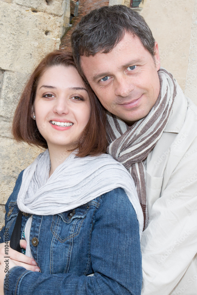 Cheerful couple looking at camera outdoors