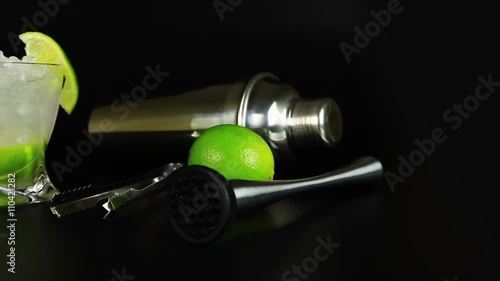 Caipirinha with cachaca, sugar and lime, bar tools on black background photo