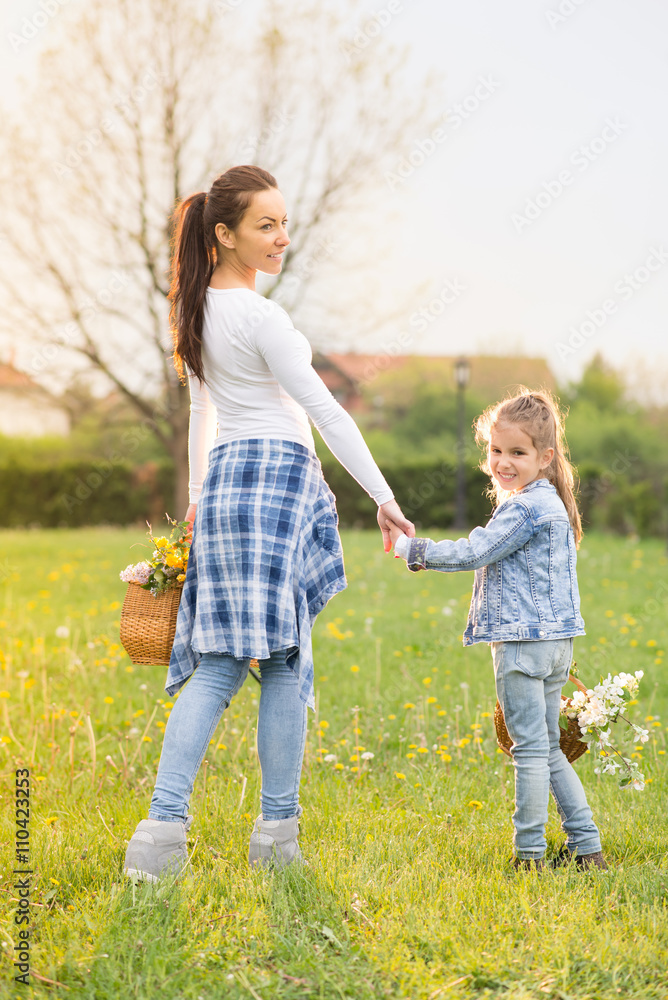 Beautiful young mother with her five years old daughter standing on the grass,and playing ,colored photo Beautiful young mother with her five years old daughter standing on the grass,and playing ,colored photo