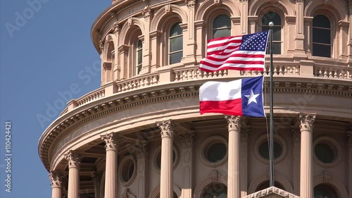 American and Texas state flags flying on the dome of the Texas State Capitol building in Austin
