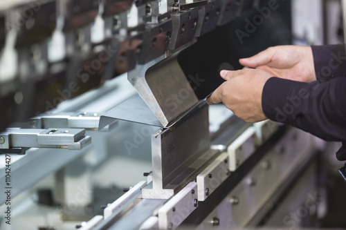 operator bending metal sheet by sheet bending machine