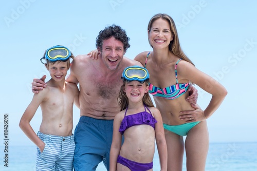 Happy family in swimwear standing at sea shore