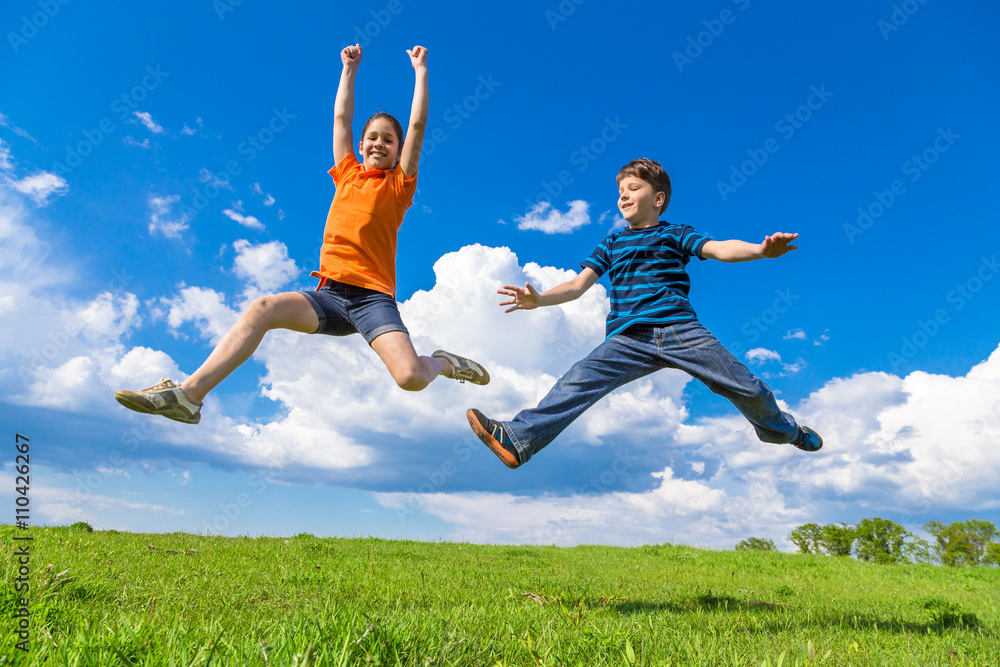 Kids jumping on green hills