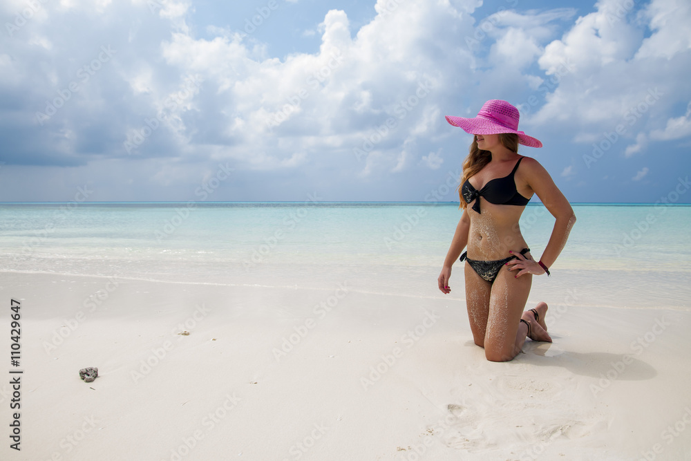 sexy girl in black swimsuit, hat and sunglasses on his knees in sexy girl in black swimsuit, hat and sunglasses on his knees in