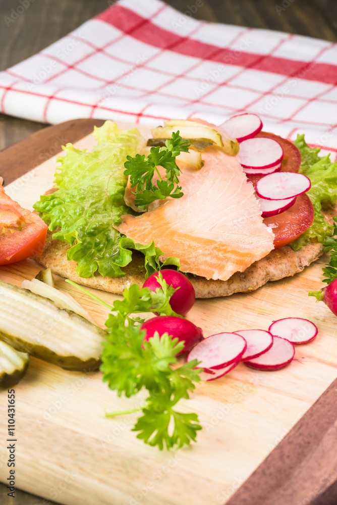 Fresh homemade pita sandwich with hot smoked salmon, letuce and vegetables. Fresh homemade pita sandwich with hot smoked salmon, letuce and vegetables.