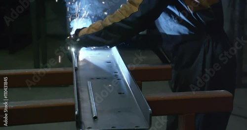 Wallpaper Mural A worker assembling a metal part using a welding machine inside the factory Torontodigital.ca