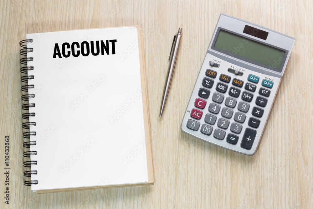 Top view of Account wording on notebook with calculator and pen Top view of Account wording on notebook with calculator and pen