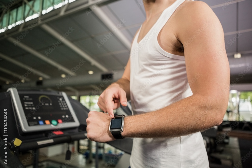Man using smart watch on treadmill