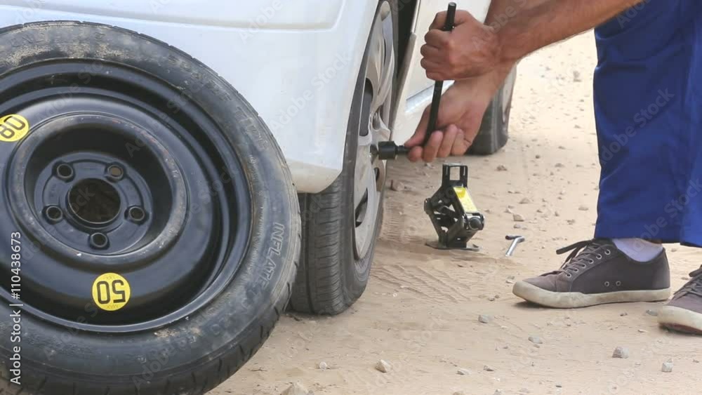 Man in uniform fixing a flat tire Man in uniform fixing a flat tire