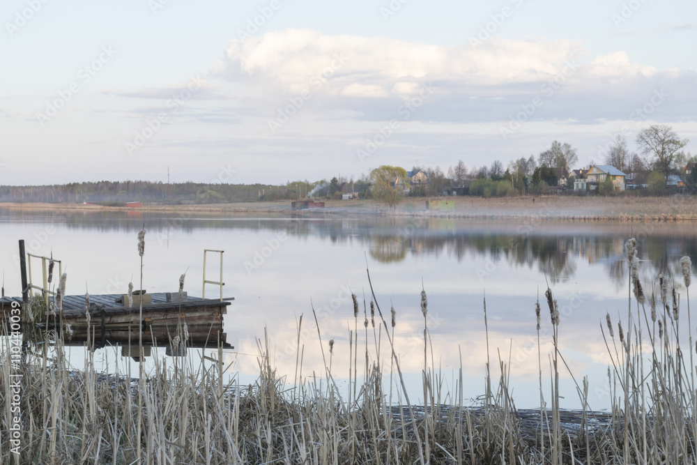 A small landing stage on the calm river in the rural area in the European part of Russia.