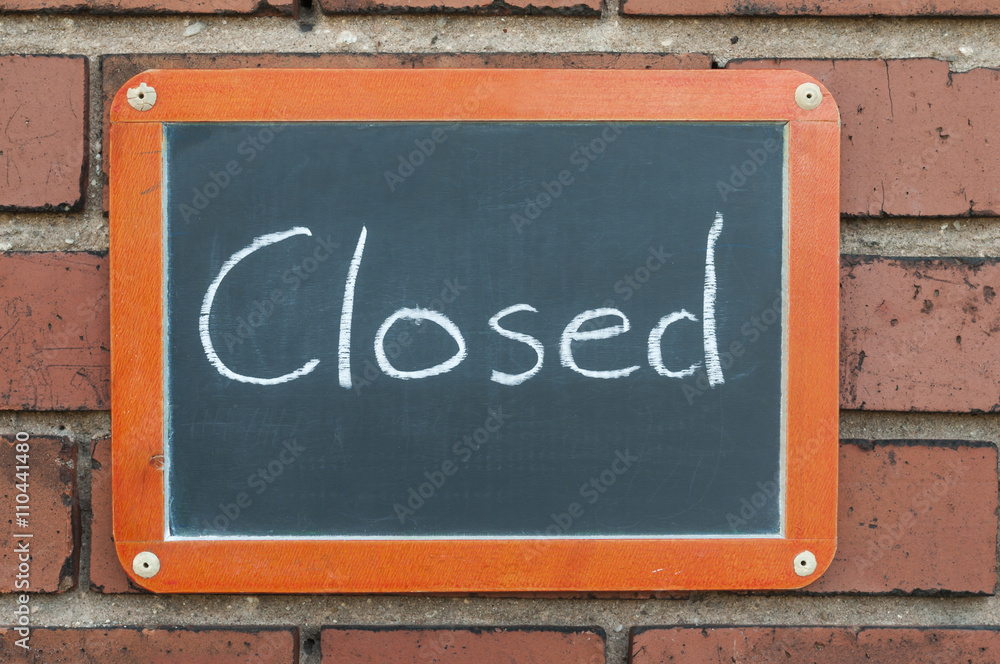 Tafel an einer Ziegelwand mit Text / Tafel an einer Ziegelwand mit Text Closed.