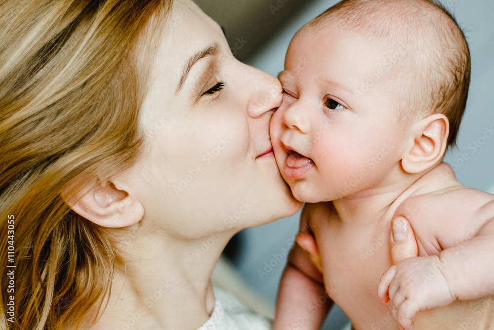 happy family mother and baby having fun playing, kissing on the bed happy family mother and baby having fun playing, kissing on the bed