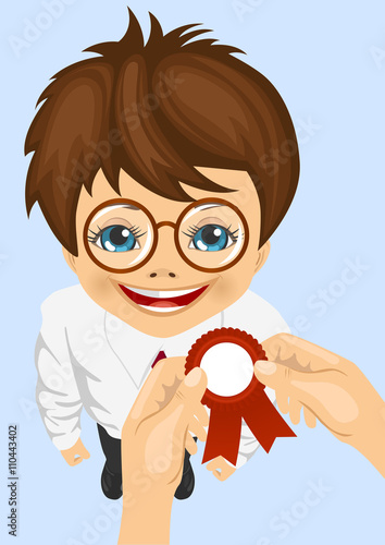 somebody pins award ribbon to chest of schoolboy won school competitions