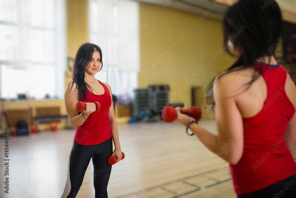 Woman doing a workout with dumbbells at the gym Woman doing a workout with dumbbells at the gym
