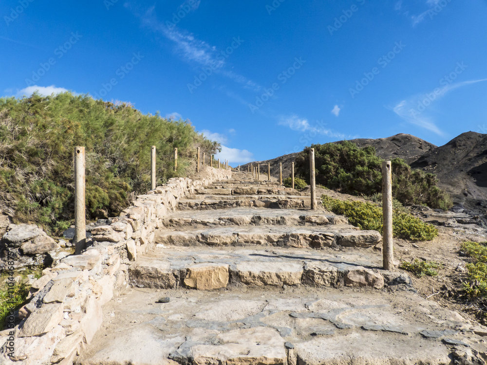 Upward stone stairs against blue sky.