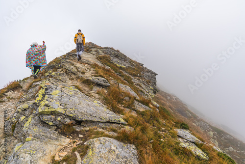 Hiking Trail with Tourists on the Hill in the Mountains in the Mist © kaycco