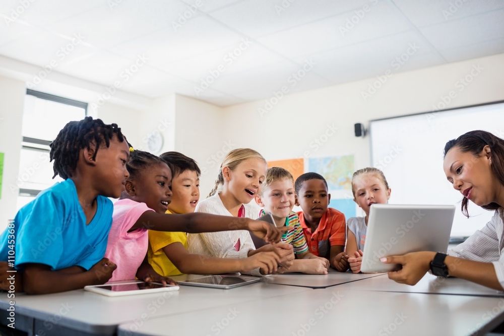 A teacher giving lesson with tablet computer A teacher giving lesson with tablet computer
