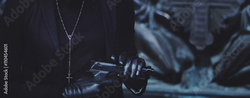 Photography close-up hands of girls in black leather gloves, grip gun