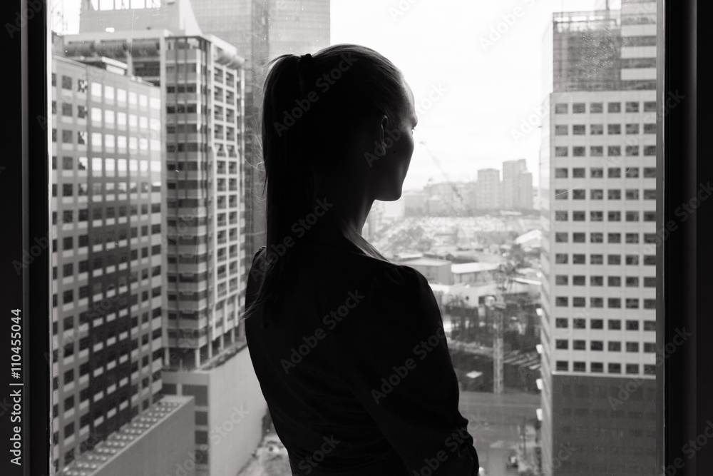 © kieferpix - Woman in her office looking out the window. © kieferpix - Woman in her office looking out the window.