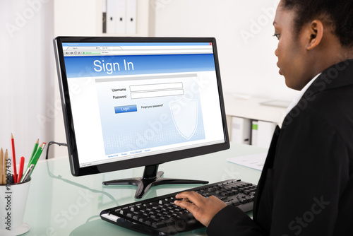 Businesswoman Signing Into Website On Computer
