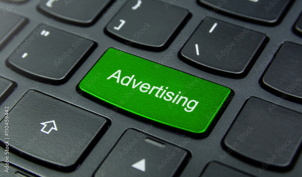 Business Concept: Close-up the Advertising button on the keyboard and have Lime, Green color button isolate black keyboard Business Concept: Close-up the Advertising button on the keyboard and have Lime, Green color button isolate black keyboard