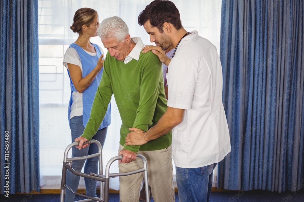Fototapeta premium Nurse helping seniors walking with a walker