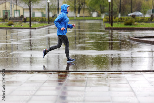 Runner woman running in Park in the rain. Jogging training for m