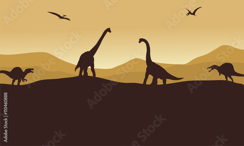 Silhouette of many dinosaur in hills