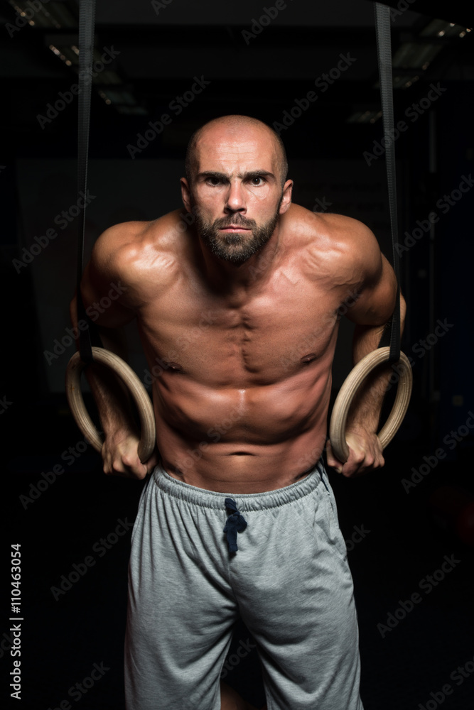 Muscular Athlete Hanging On Gymnastic Rings