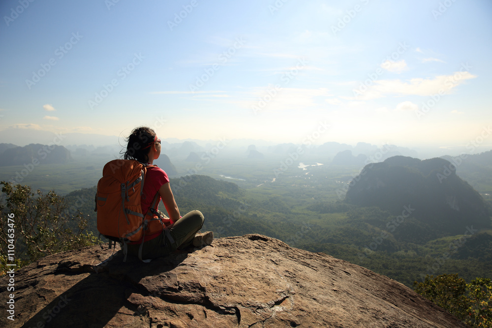 successful woman hiker enjoy the view at sunrise mountain peak